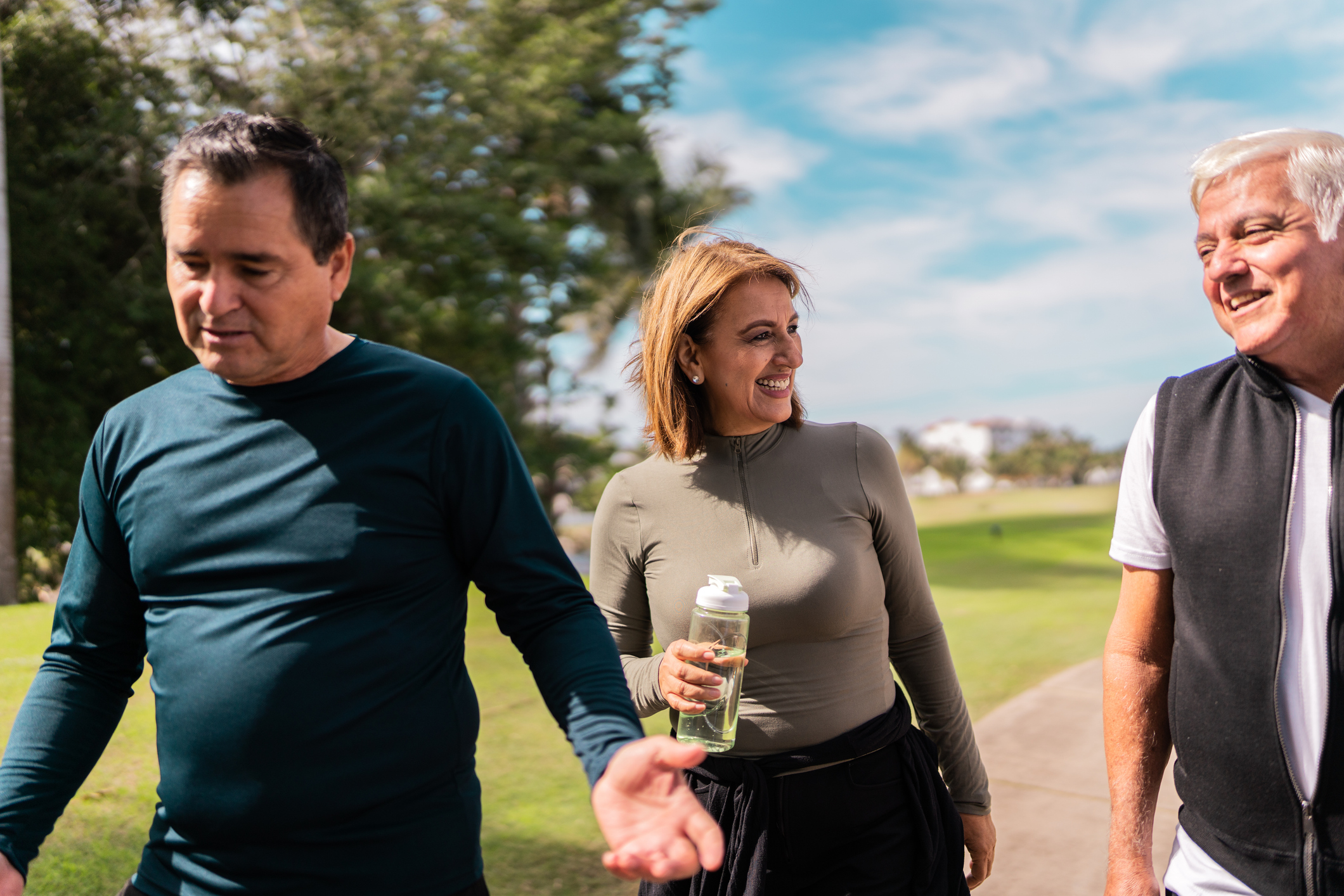 Senior Friends Walking And Talking At Public Park