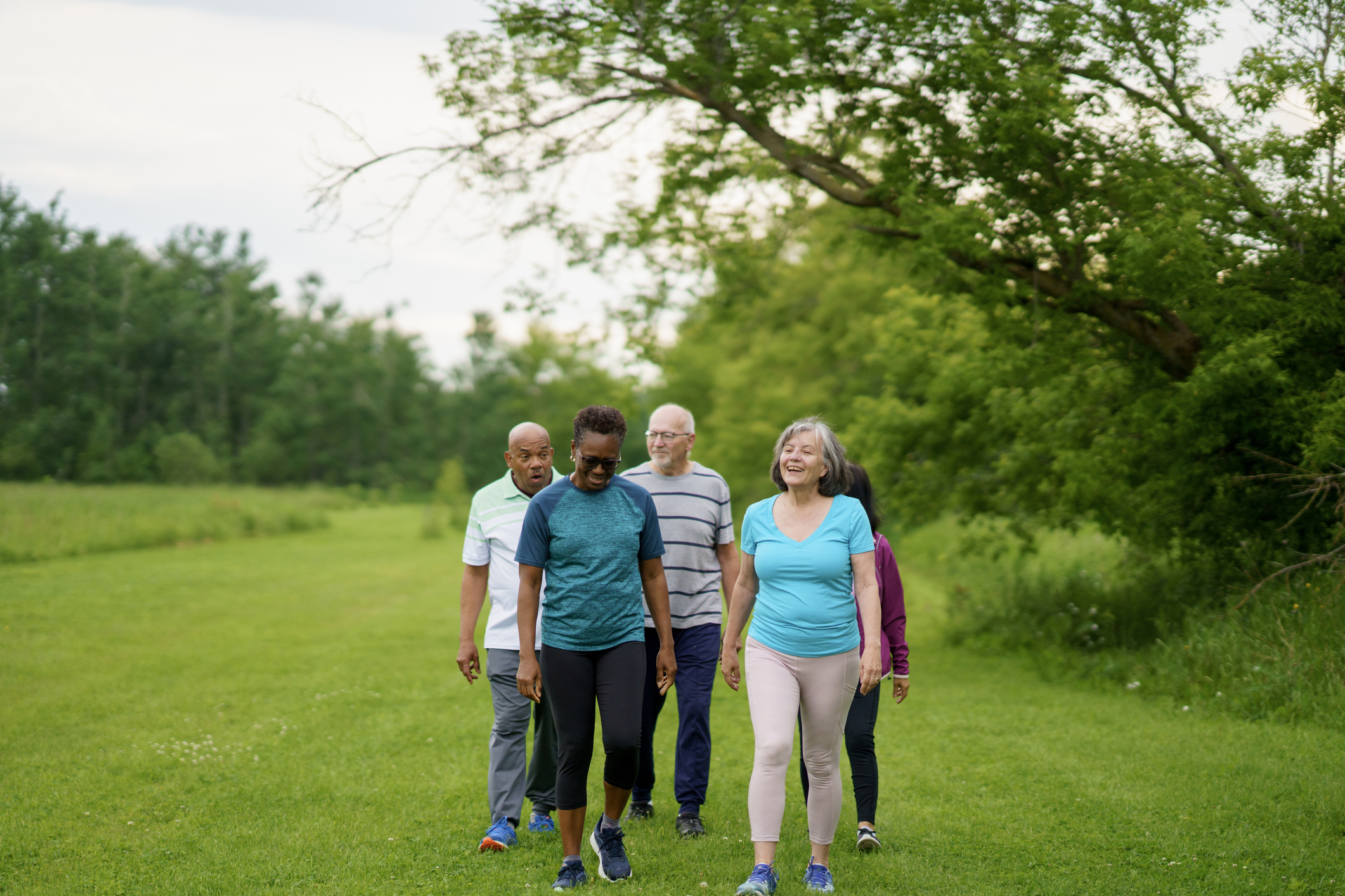Group Of Friends Enjoying A Relaxing Walk Outdoors In A Park